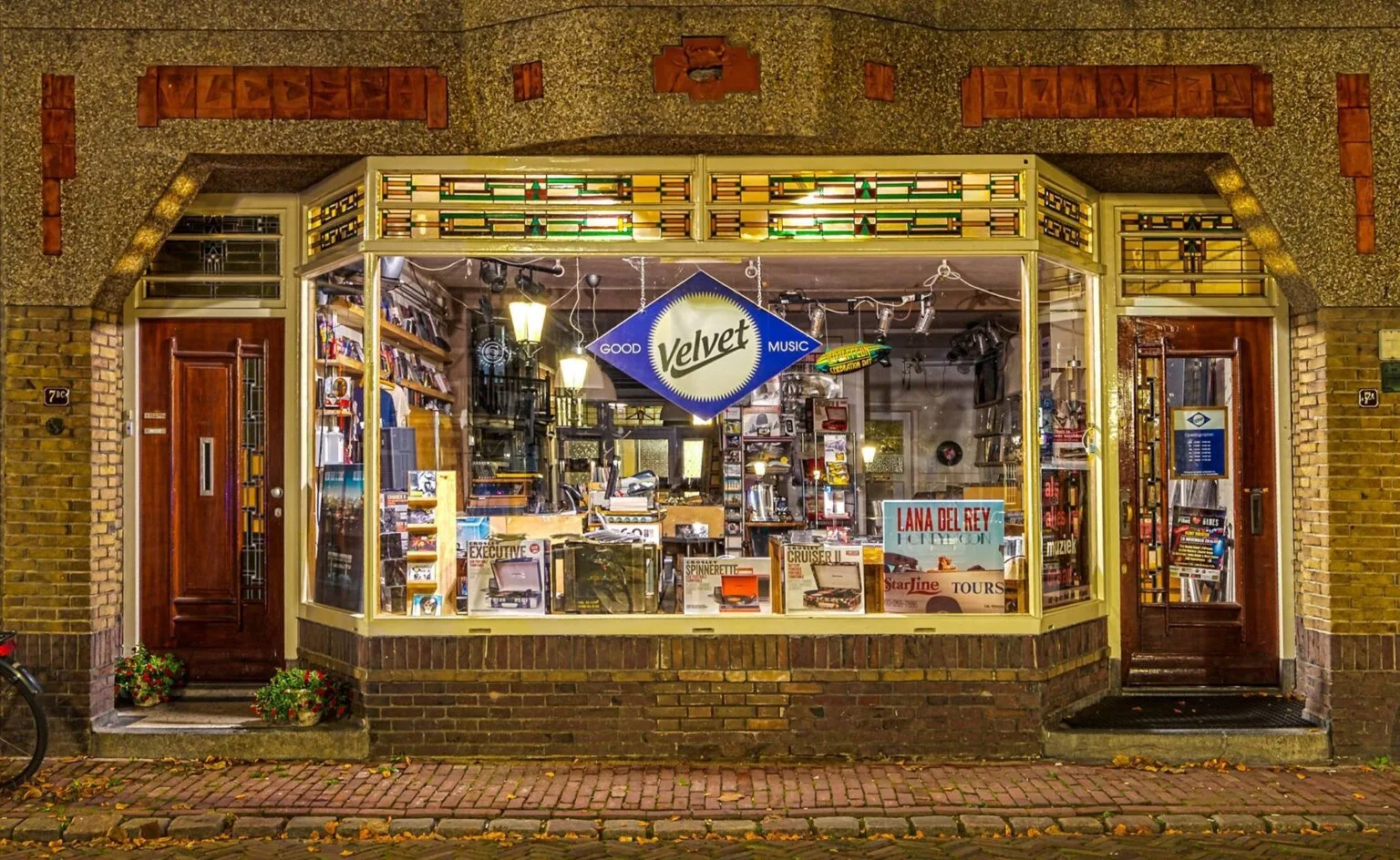 Muziekwinkel gevel bij nacht in Nederland.