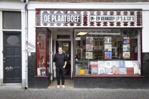 Man voor platenzaak 'De Plaatboef' met LP's.