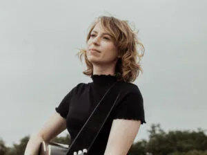 Vrouw met gitaar op veld