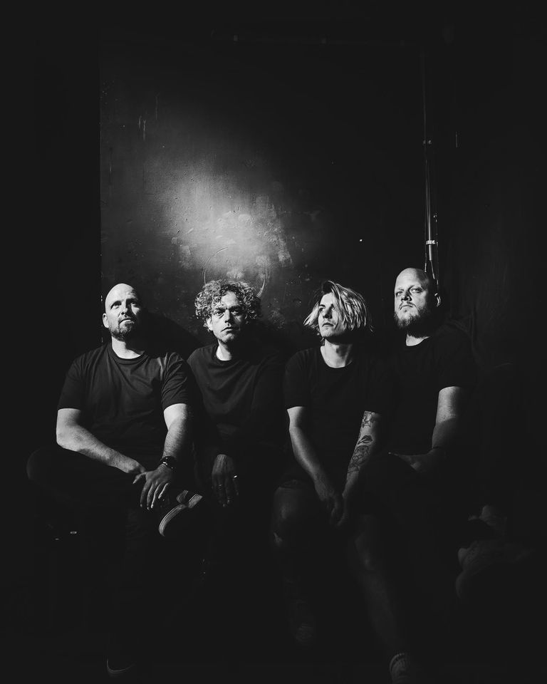Vier mannen in zwart-wit portretfotografie.
