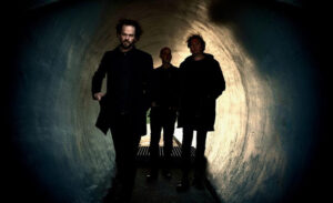 Drie mannen in donkere tunnel, silhouet, mysterieus.