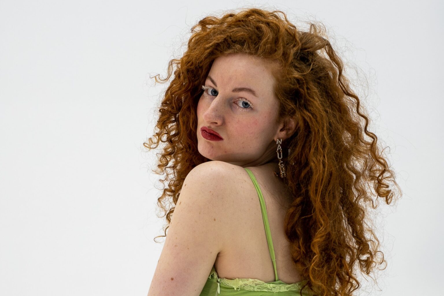 Vrouw met rood krullend haar in groene top