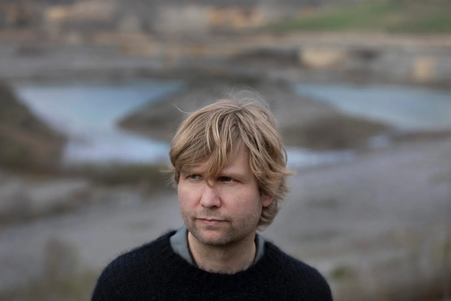 Man met blond haar in natuurlijke omgeving