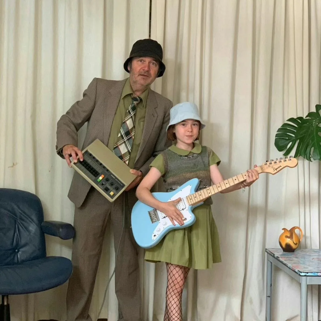 Man en meisje met computer en gitaar, vintage stijl.