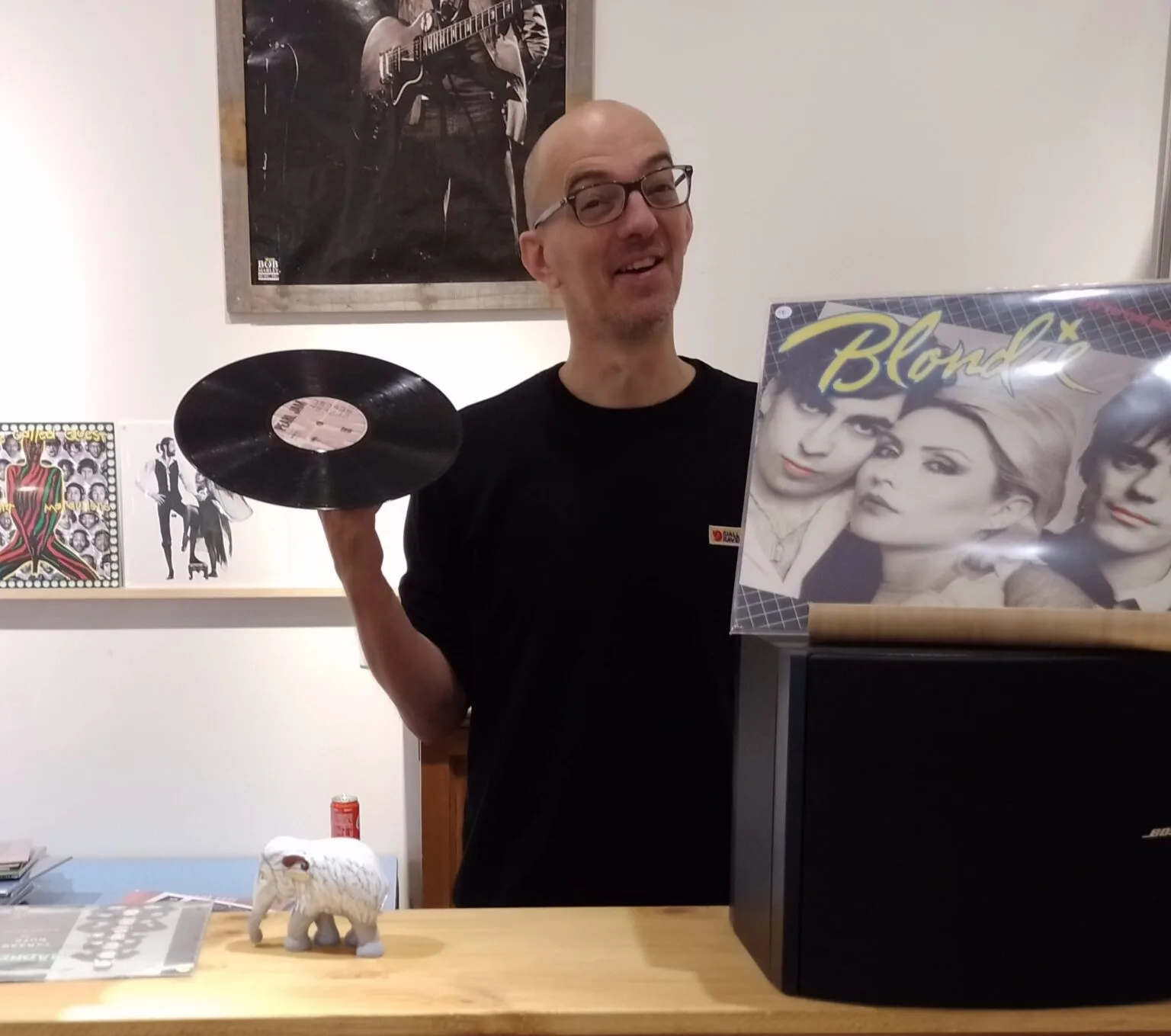 Man met vinylplaat en Blondie-album in winkel.