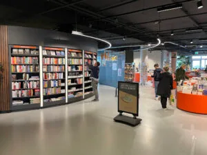 Boekwinkel met klanten en gevulde boekenplanken.