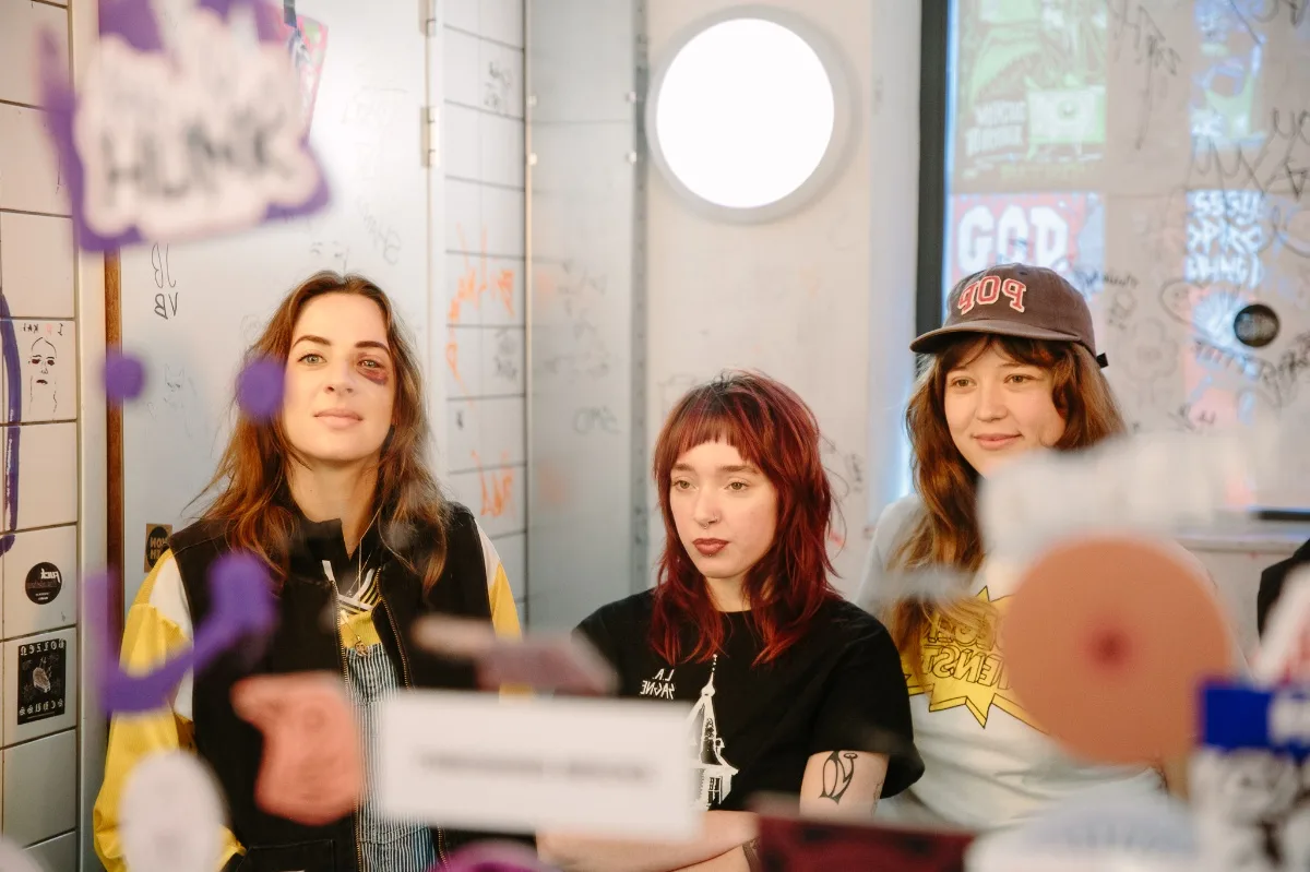 Drie vrouwen voor spiegels met graffiti.
