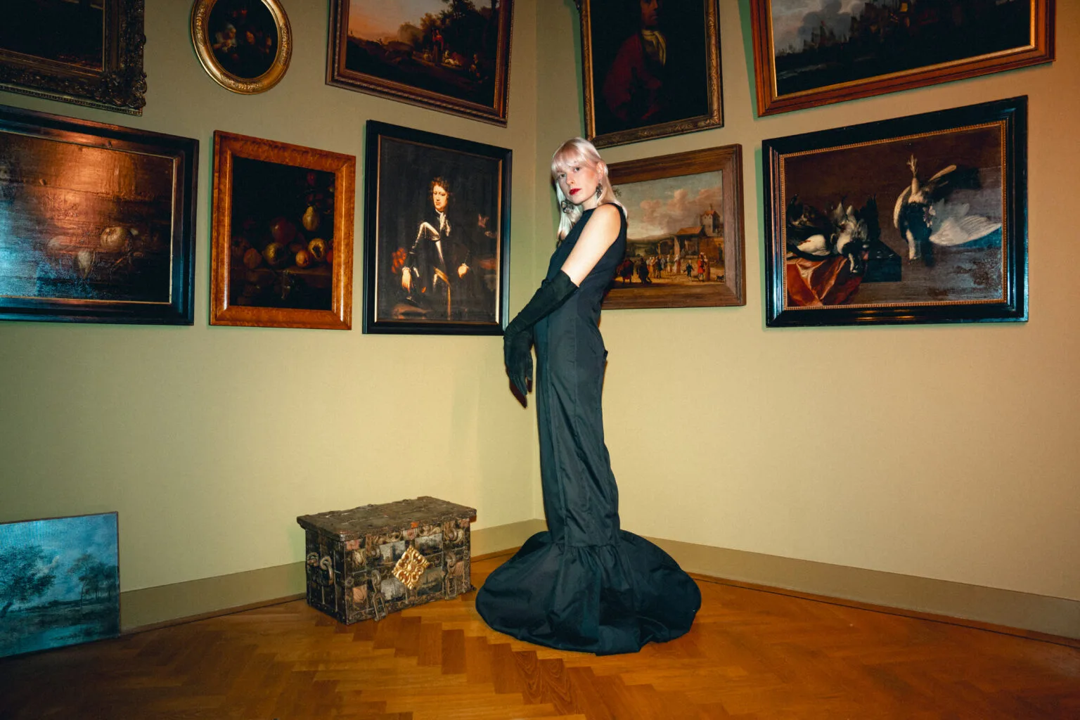 Vrouw in zwarte jurk in kunstgalerij