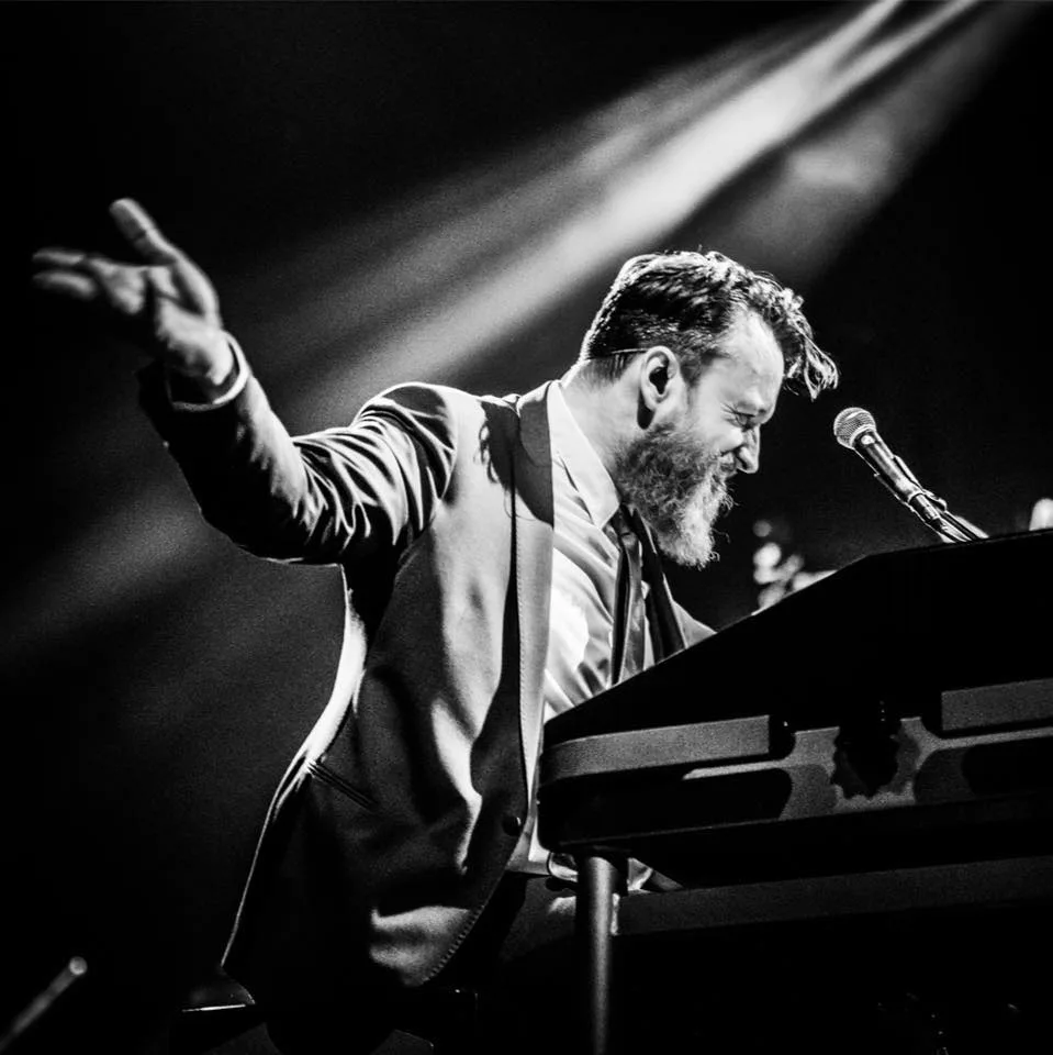 Muzikant speelt energiek op toetsenbord tijdens concert.