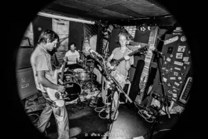 Band speelt live muziek in kleine ruimte.